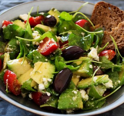 Delicious Greek salad featuring avocado, feta, and olives, ideal for a healthy meal.