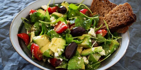 Delicious Greek salad featuring avocado, feta, and olives, ideal for a healthy meal.