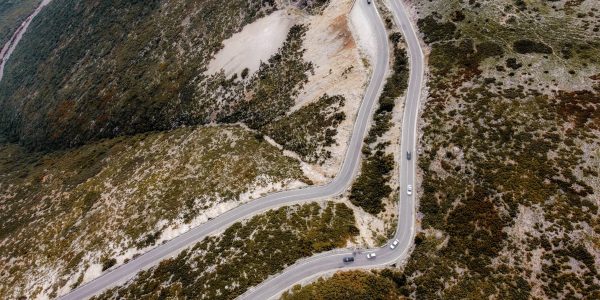 Captivating aerial shot of a winding road through autumn landscapes on a mountain.